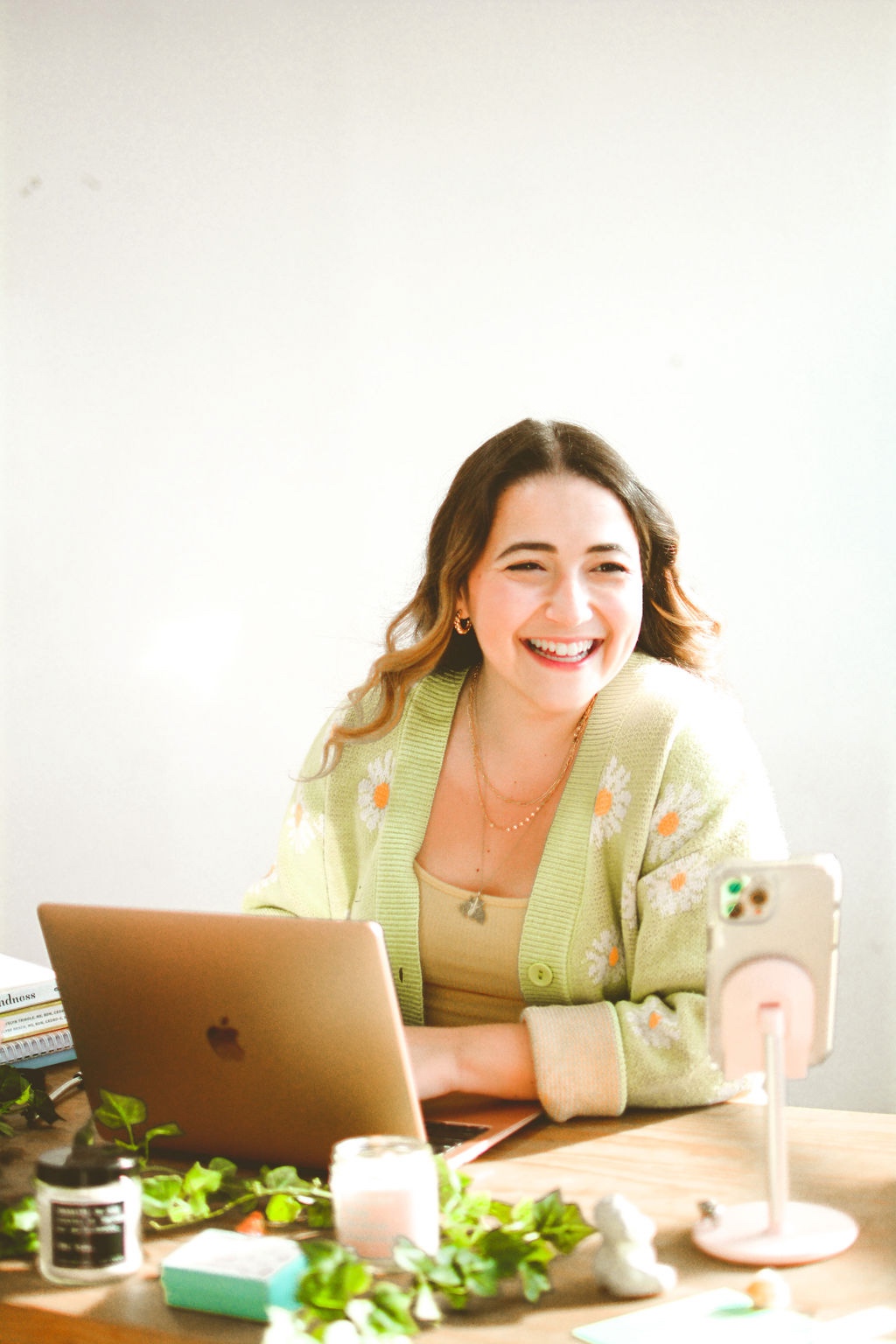 Alexandra, smiling at her computer, writing this post which focused on the importance of honoring the individual when it come to authentic health.
