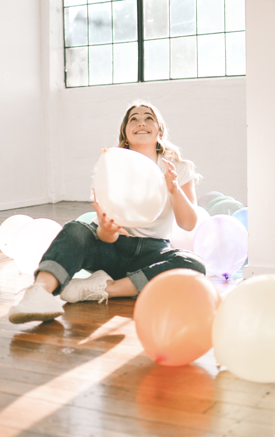Alexandra surrounded by balloons and smiling optimistically, while she celebrates body acceptance.